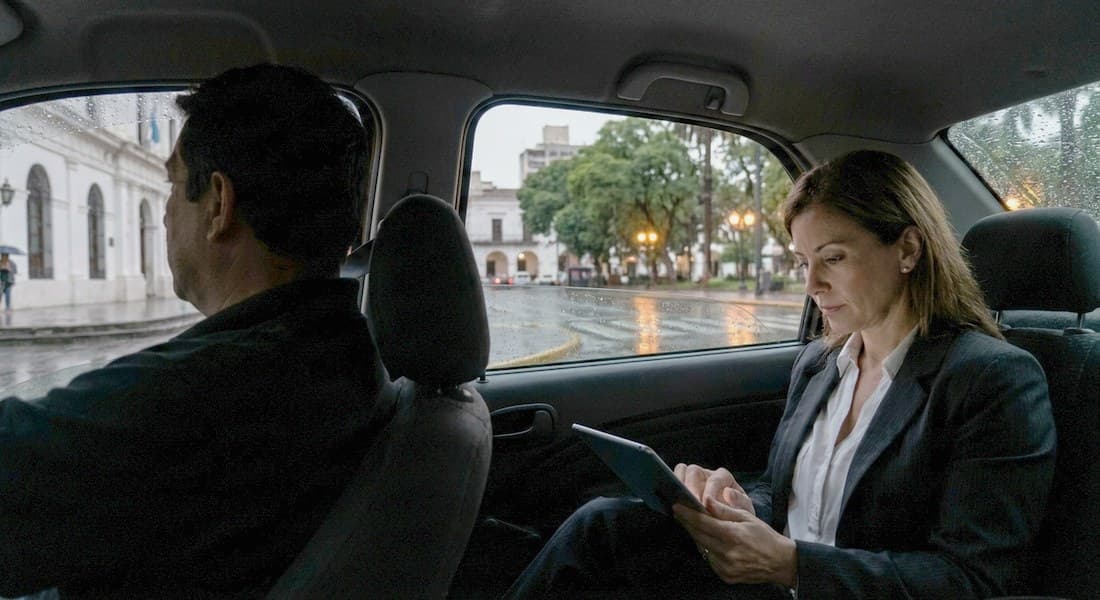 Una persona revisando quién le debe desde el asiento de atrás de un auto